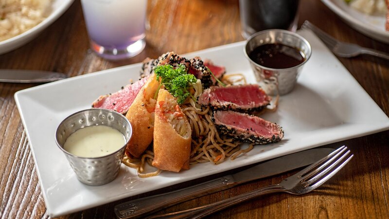Sesame crusted tuna with wasabi noodles and egg rolls